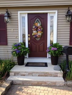 the front door is decorated with flowers and plants