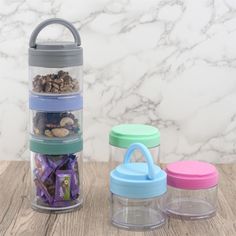 three containers with food in them sitting on a table next to a marble wall and counter top