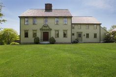 a large house sitting on top of a lush green field