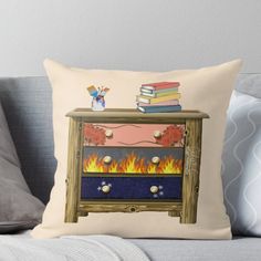 an old dresser with books on top and fire in the bottom throw pillow