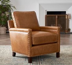 a brown leather chair sitting on top of a rug