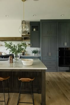 a kitchen island with two stools in front of it and an oven on the other side