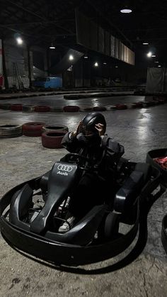 a person riding on top of a motorcycle in a parking lot with tires around it