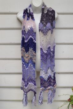 Scarf is handknitted in Chevron style Colours are various shades of purple and beige Is OOAK Scarf is 22cm wide by 170cm long Care is handwash in lukewarm water. squeeze gently and dry flat Seller does not ship to Europe One Size Scarf Knitting Pattern, Hand Knitted Yarn Scarves, Hand Knitted Purple Knitting Pattern, Purple Crochet Yarn Scarves, Purple Crochet Scarf One Size, Purple Crochet Scarves One Size, One Size Purple Crochet Scarf, Purple Yarn Scarf, Pastel Scarf