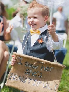 a little boy holding a sign that says, i saw her she's beautiful