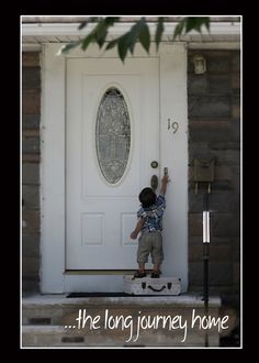 a little boy standing in front of a white door with the words the long journey home written on it