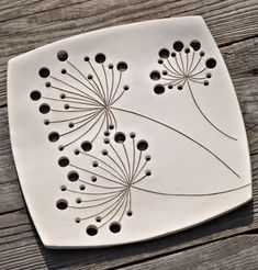 a white plate with holes in the center on a wooden surface, showing an intricate design