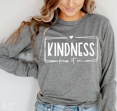 a woman wearing a sweatshirt that says be kind