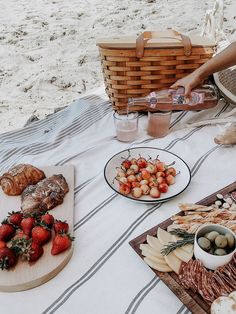 a table topped with plates of food on top of a beach