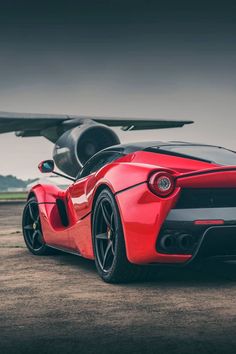 a red sports car parked in front of an airplane