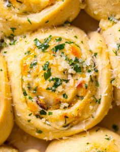 close up view of some food with cheese and herbs on top, as well as parmesan sprinkles