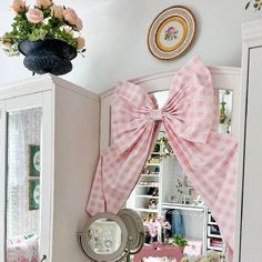 a pink bow tie on the back of a cabinet in a room with white walls