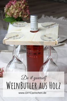 two wine glasses sitting on top of a wooden tray next to a bottle of wine