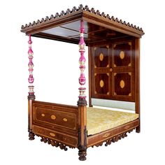 a wooden bed with pink and gold decorations on it