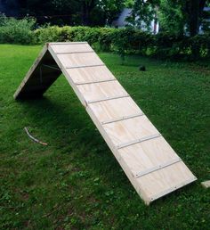 a wooden ramp sitting on top of a lush green field