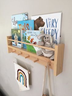 a shelf with books and stuffed animals on it in a child's room or playroom