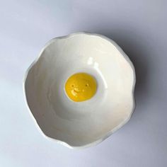 an egg is in the shape of a bowl with a smiley face painted on it