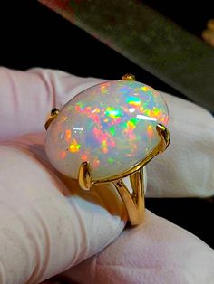 Very bright beautiful, I can't help imagining an Australian white opal of this size and color, you would need a second mortgage to own it, the only difference is you shouldn't get it wet for extended period of time. I have now sold literally thousands of opals and only a couple complaints of chafing. Large oval white  fire opal 16x23mm 18cts. Mounted on a large simple solitaire solid 14k gold ring, I like the simplicity and solidness of this ring. It's heavy for its size. Prongs will be set when White Gold Opal Ring, Large Engagement Rings, Black Opal Jewelry, Australian Opal Jewelry, White Opal Ring, Rainbow Opal, Fire Opal Ring, Opal Ring Gold, Art Earrings