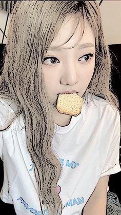 a girl with long hair eating a cookie