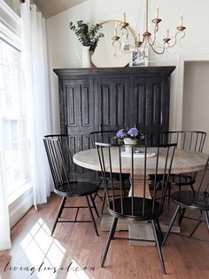 a dining room table with six chairs and a chandelier hanging from the ceiling