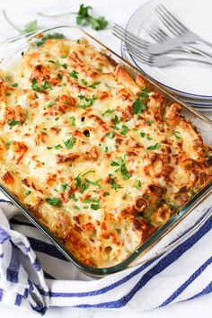 a casserole dish with meat and cheese in it on a blue and white towel