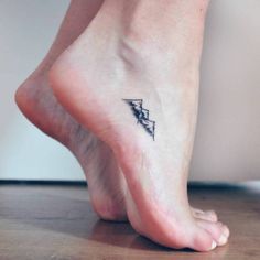 a woman's foot with a lightning bolt tattoo on her left ankle and an arrow in the middle