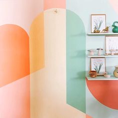 a room painted in pastel colors with shelves and vases on the wall behind them