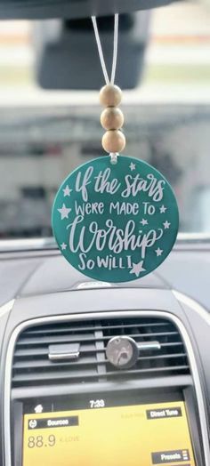 a car dashboard with a sign that says if the stars were made to worship so will i