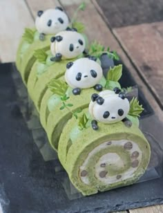 there is a roll with panda bears on it and green leafy toppings in the middle