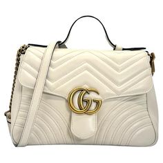 Experience luxury and style with the Gucci GG Marmont Top Handle Small Crossbody Bag. Made in Italy with white matelassé chevron leather and antique gold-tone hardware, this versatile bag exudes elegance. It features a push snap closure at the front, a microfiber interior with a suede-like finish, and includes a detachable crossbody strap. Perfect for any occasion, add this stunning bag to your collection today. Brand: Gucci Origin: Made in Italy Date/Authenticity Code: 498110•204991 Material: W Gucci Gg Marmont, Gg Marmont, Small Crossbody Bag, Small Crossbody, Crossbody Strap, Fashion Handbags, Antique Gold, Snap Closure, Top Handle