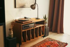 a record player is sitting on top of a shelf next to a rug and window