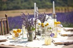 the table is set with flowers and candles for an outdoor dinner party or wedding reception