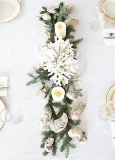 the table is decorated with white flowers and seashells for a festive touch