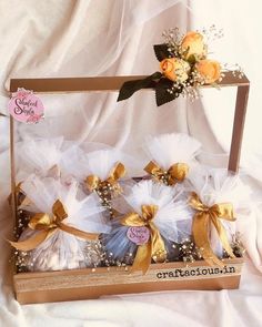 the small baskets are decorated with gold ribbons and tulle bows, as well as baby's breath flowers