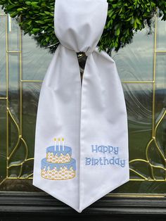 a white birthday tie with a blue cake on it