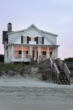 a house on the beach with stairs leading up to it