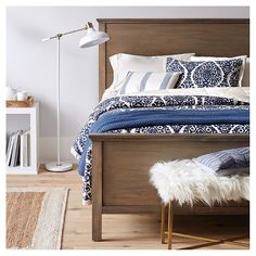 the bed is made up with blue and white sheets