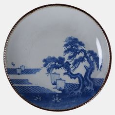 a blue and white plate with a tree on it