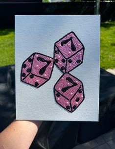 two pink dices are being held up in the air by someone's hand