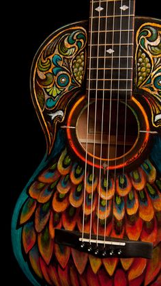 a colorful guitar with an intricate design on the top and bottom, sitting in front of a black background