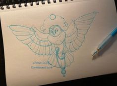 a drawing of an owl with wings and a bell on it's head is next to a pen