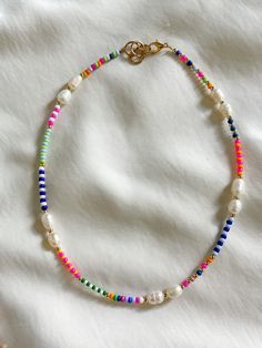 This multicolor freshwater pearl necklace is the perfect necklace for the daytime. It's unique in style and pattern. This necklace is 15 inches in length with an inch for adjustment. All jewelry comes with a Beaded by Sandy care card explaining the best ways to take care of your jewelry.  Designed and handmade just for you in the USA. Personal message from the owner of Beaded by Sandy: Hello! Thank you so much for the support and continuous love. I am a teenager from South Texas who loves making jewelry and creating art. I started my small business back in 2019. I have participated in local market events and have made Beaded by Sandy known in my small town. I am thankful for my followers, supporters, and family for the genuine love! Please message my Instagram for any questions.   IG: @bea Beaded Necklace Colorful, Fun Beaded Necklaces, Diy Bead Necklace Ideas, Multicolor Beaded Necklace, Beaded Necklace Inspiration, Handmade Necklaces Diy, Beaded Jewelry Inspiration, Beads Necklace Design, Seed Bead Necklace Ideas