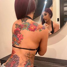 a woman is looking at herself in the mirror