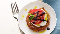 a white plate topped with food on top of a blue cloth next to a fork