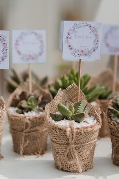 small succulents in burlap baskets with place cards on sticks for seating