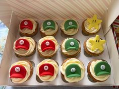 a box filled with cupcakes covered in frosting and decorated like mario bros hats