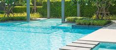 an empty swimming pool with steps leading to it and trees in the backgroud