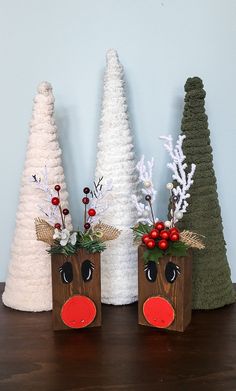 three small wooden christmas trees with fake noses and nose decorations on them, sitting next to each other