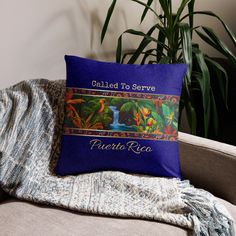 a blue pillow sitting on top of a couch next to a potted green plant