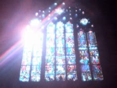 the sun shines brightly through a stained glass window